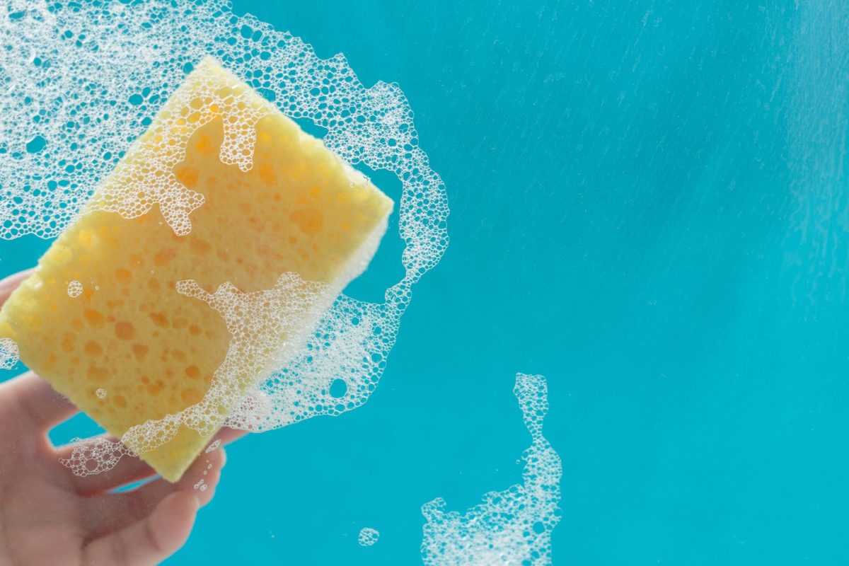 yellow soapy sponge on blue background