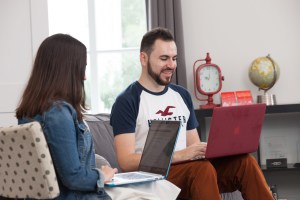 Two employees working on laptops