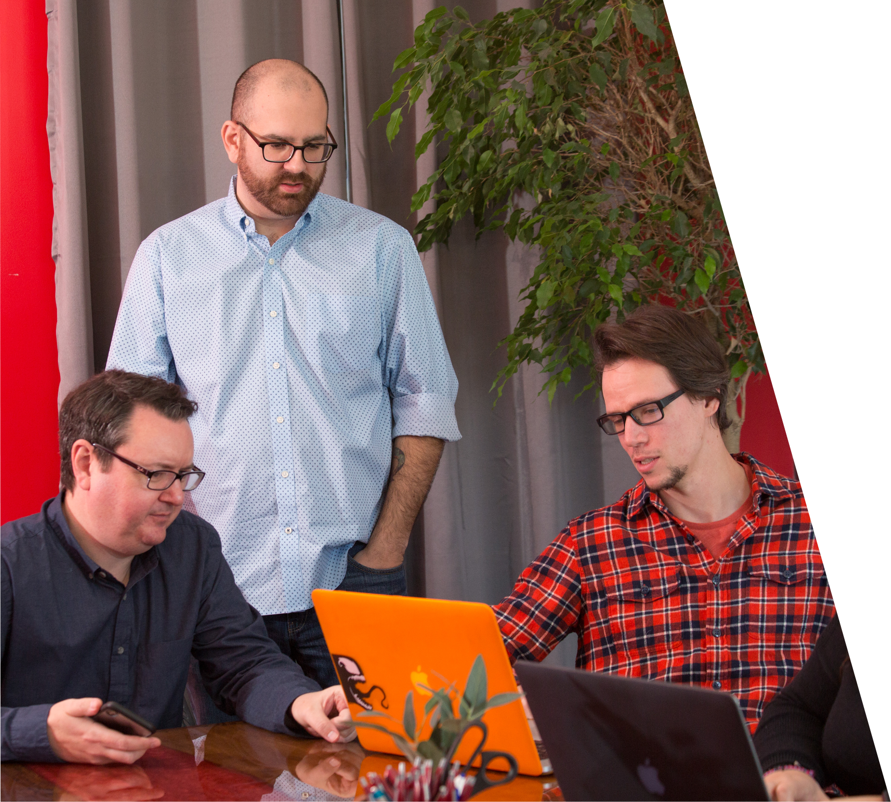 three men looking at a laptop