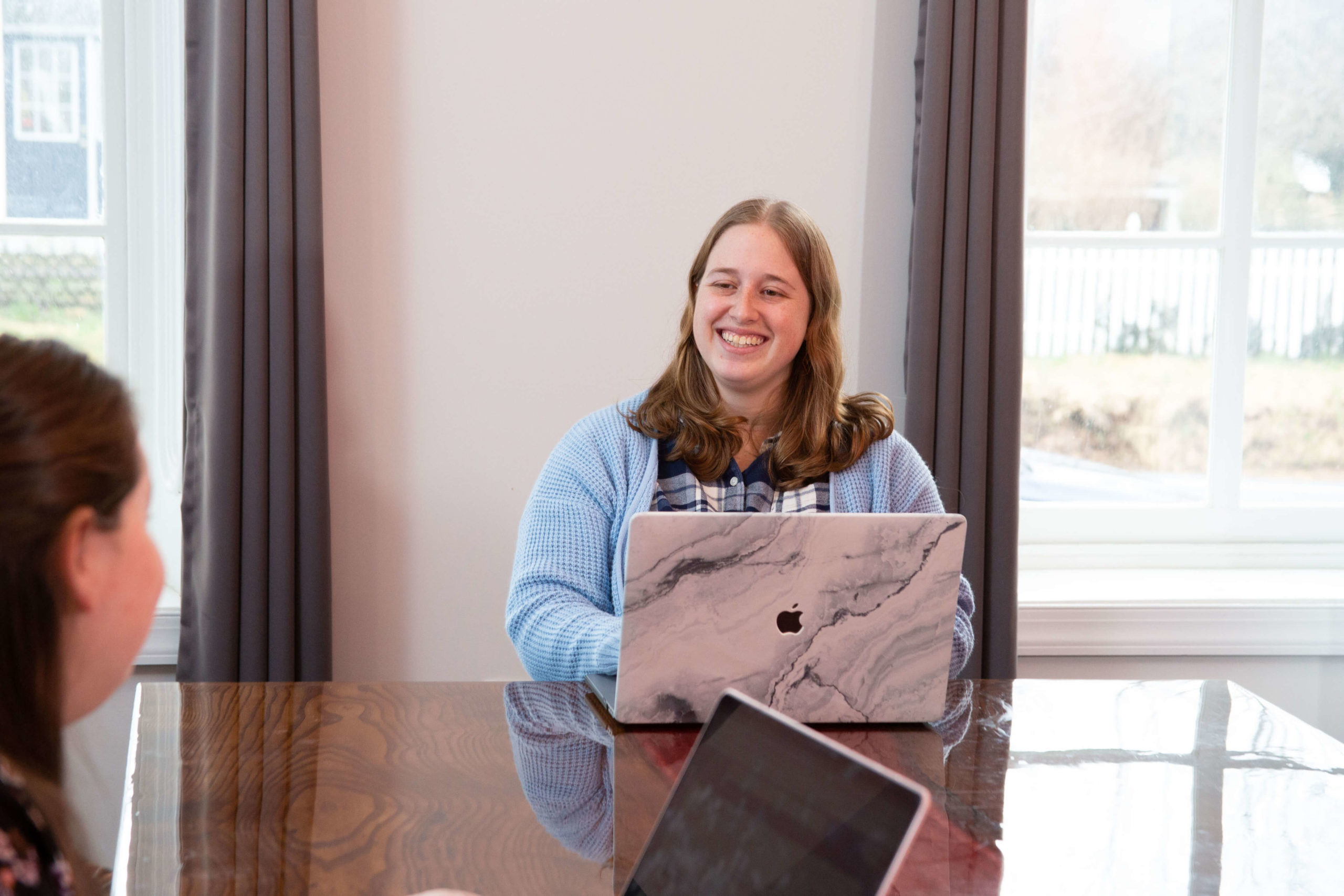 woman smiling in front of her laptop
