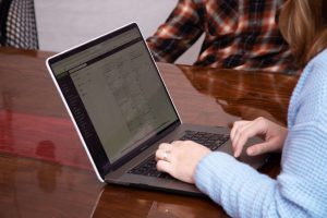 close up of hands typing on a laptop