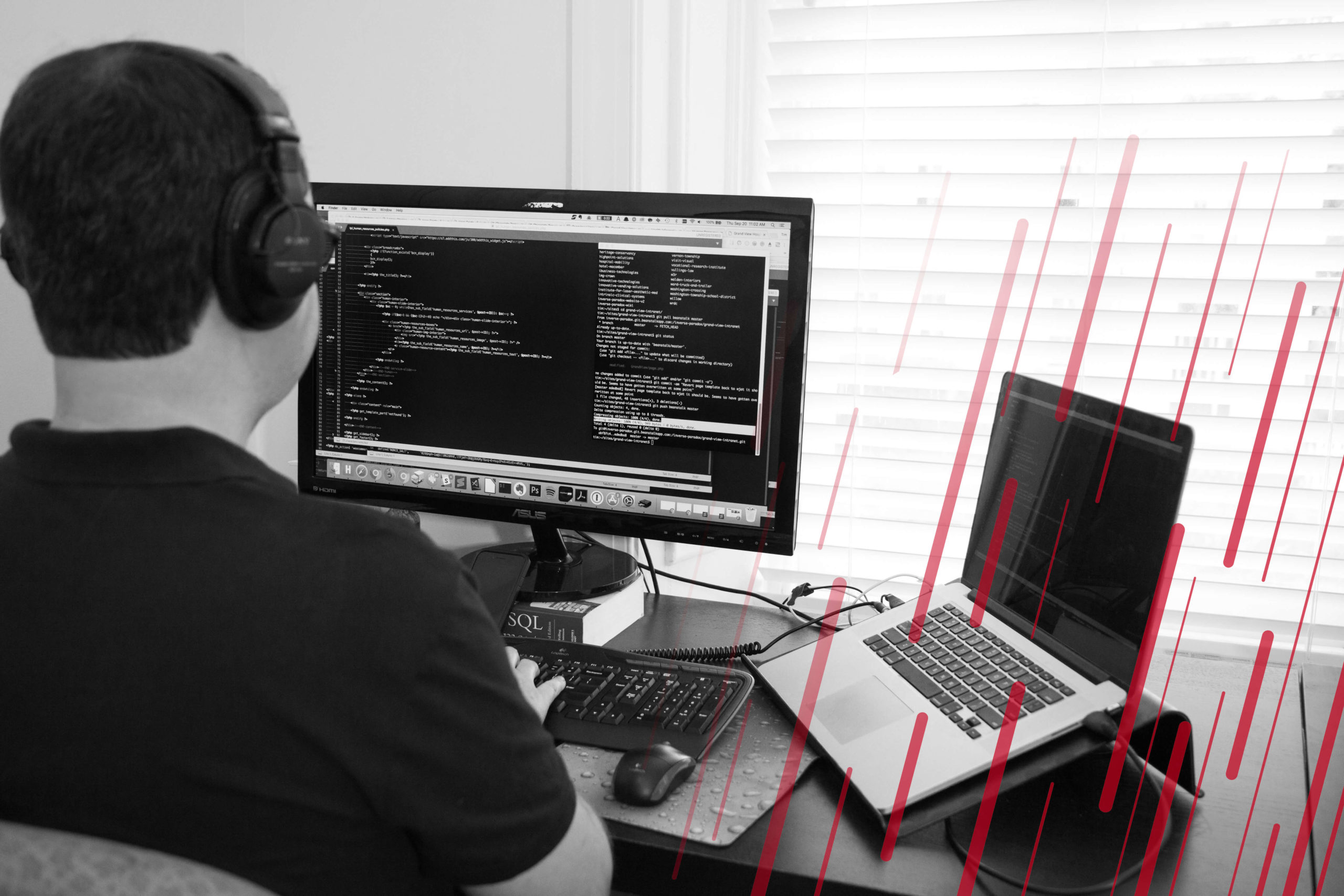 man with headphones writing code on a computer