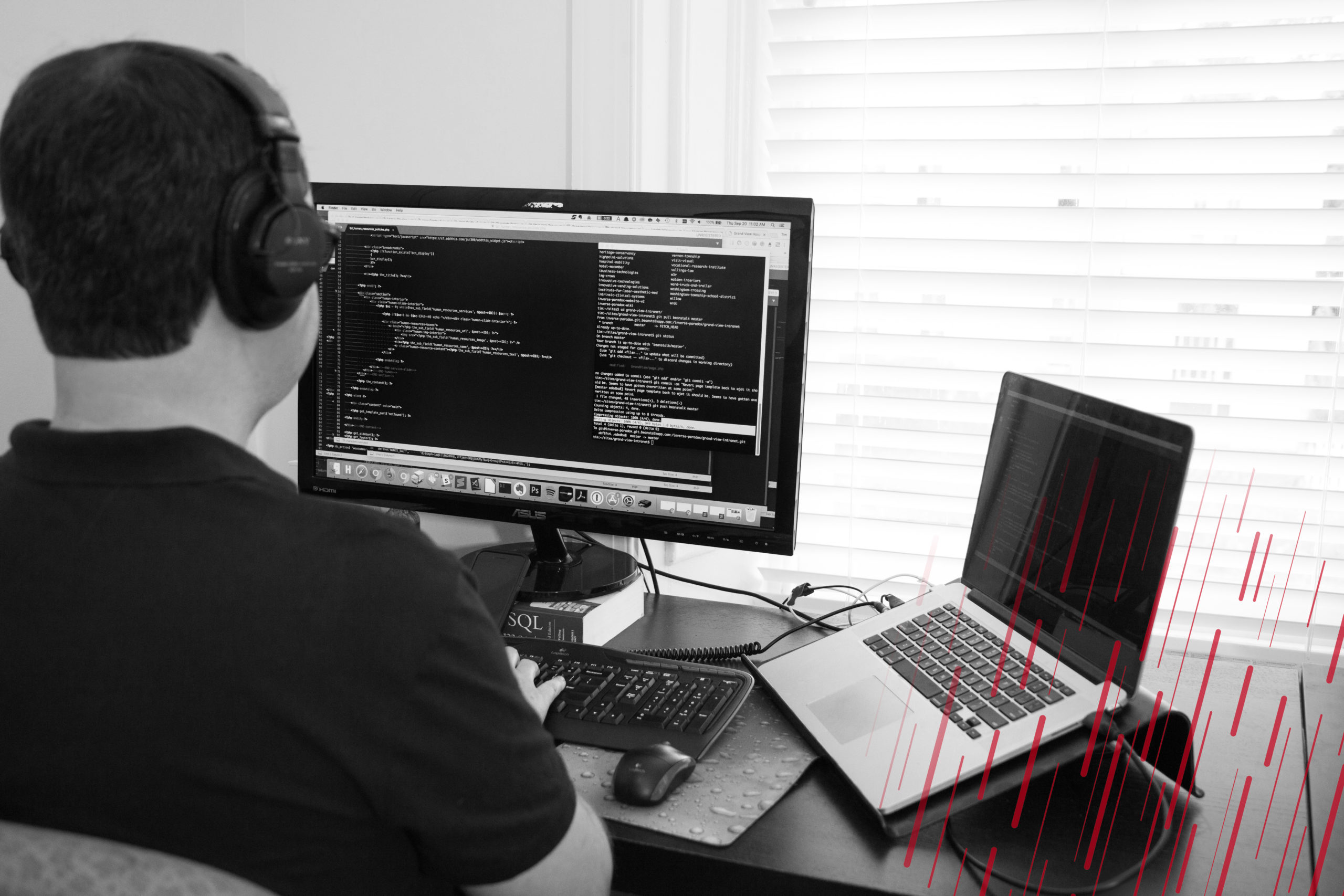 man working on a computer screen with headphones on