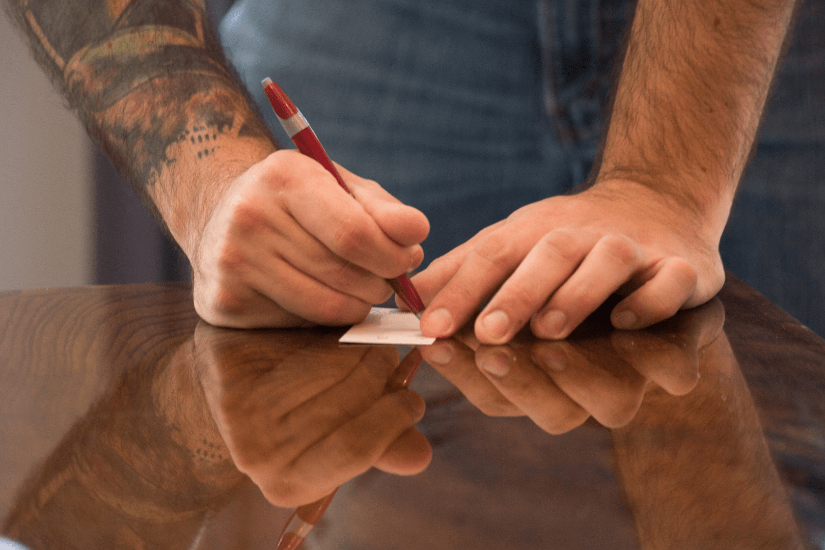 hands writing on a small piece of paper